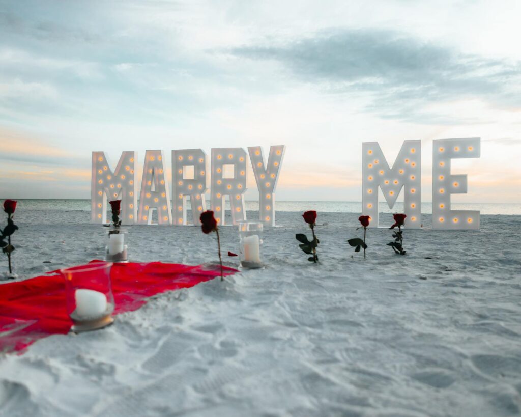 romantic beach proposal with marry me sign