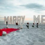 romantic beach proposal with marry me sign
