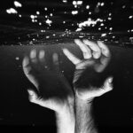 hands of crop faceless man under water