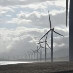 windmills on seashore under white clouds