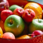 delicious multicolored apples and oranges with mandarins located in red bowl