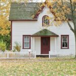 white and red wooden house with fence