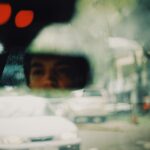 a reflection of a person on the car s head mirror