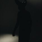 person in costume with horns standing in darkness