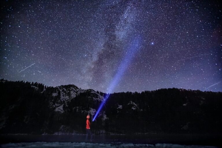 starry night sky with person and flashlight