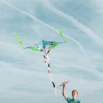 man wearing blue shirt flying kite