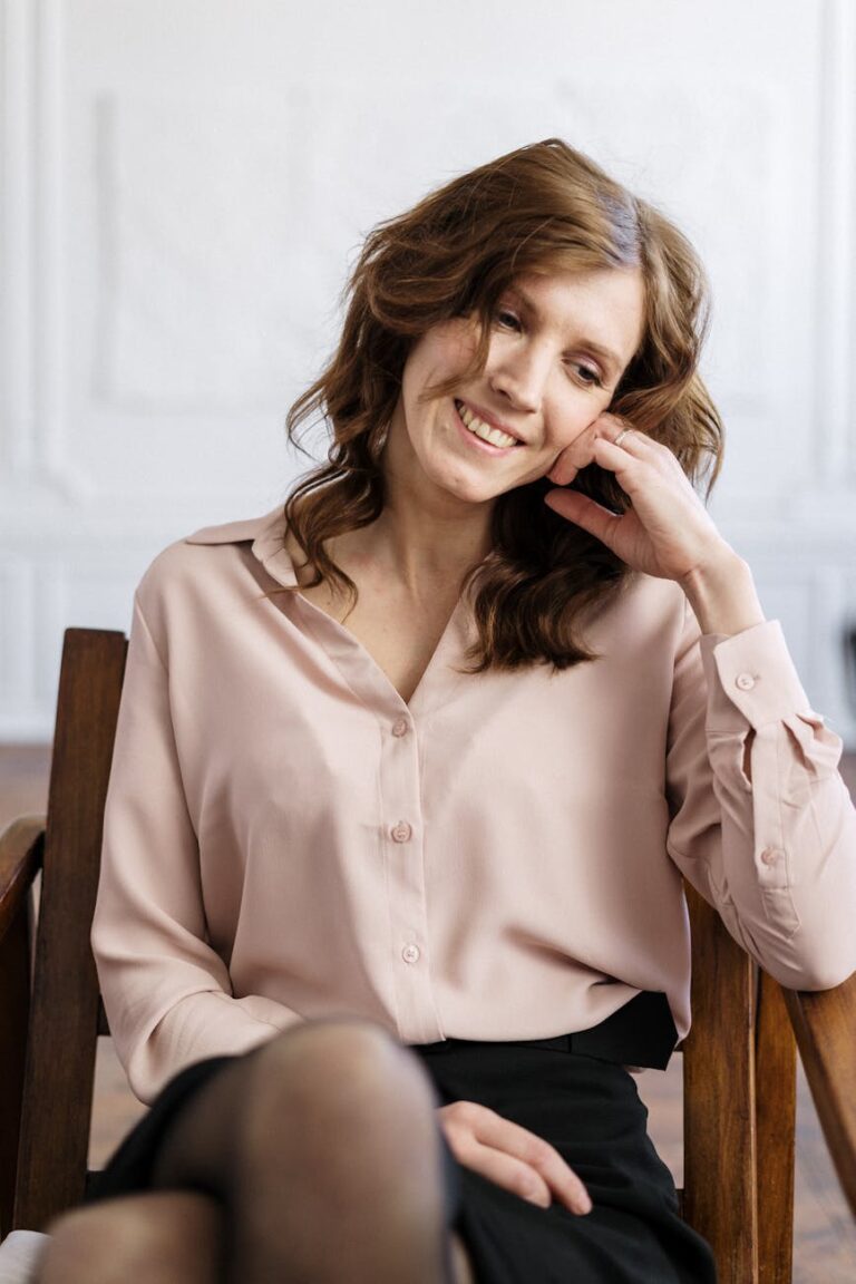 woman in white dress shirt sitting on brown wooden chair