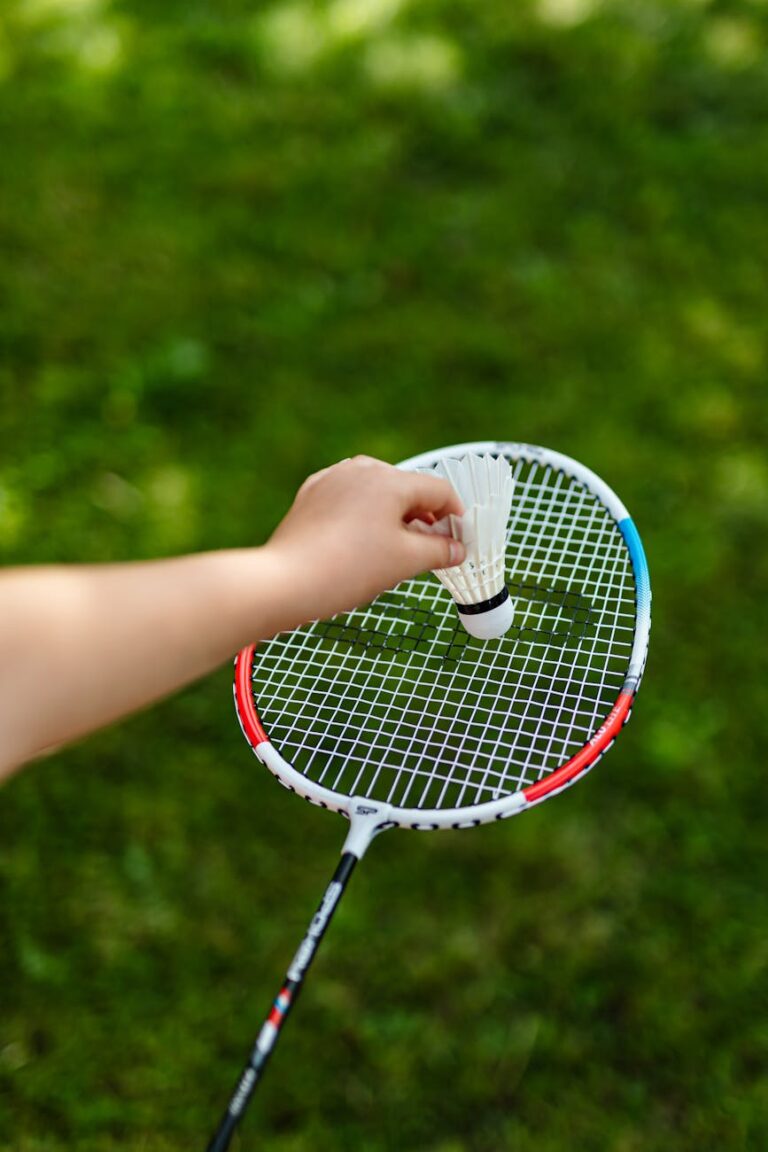 person holding white and red badminton racket