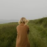 anonymous woman walking in cold field