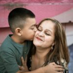 a boy kissing his mother