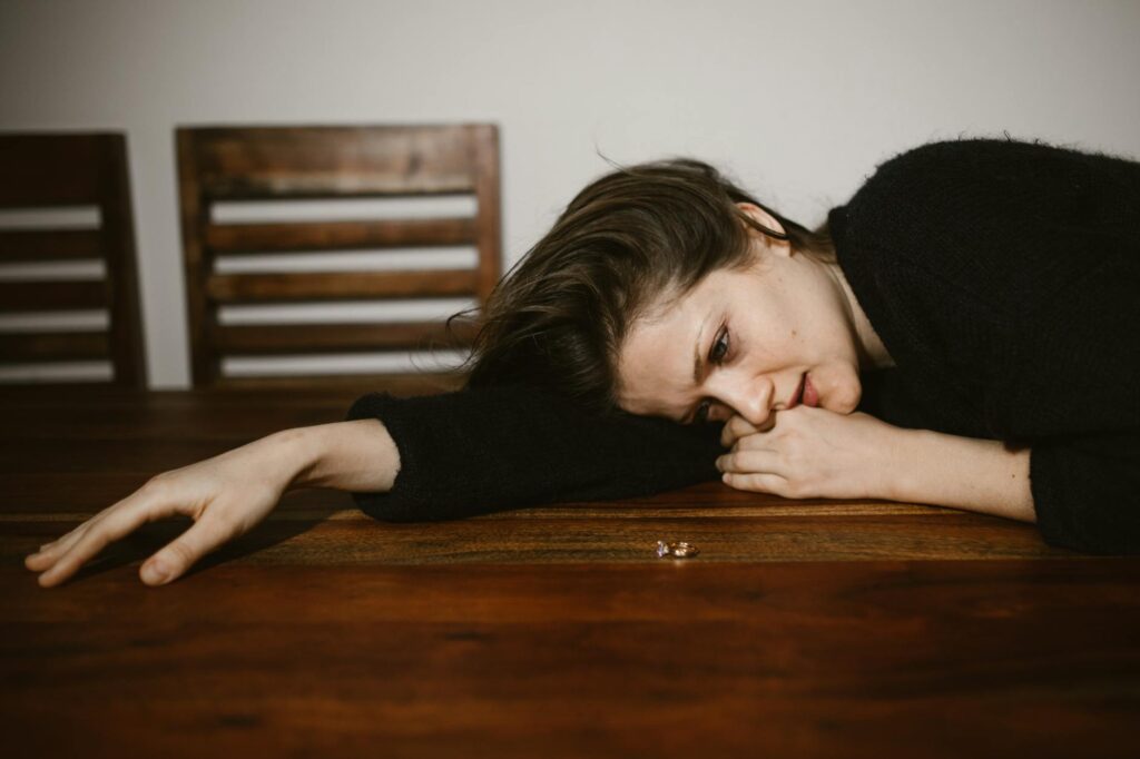 crying woman leaning on brown wooden table