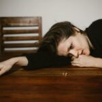crying woman leaning on brown wooden table