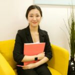 woman in black blazer sitting on yellow armchair