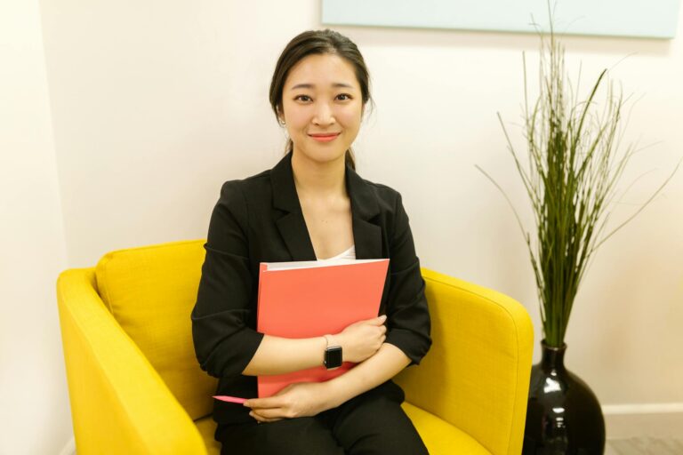 woman in black blazer sitting on yellow armchair