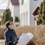 woman in blue coat holding white paper