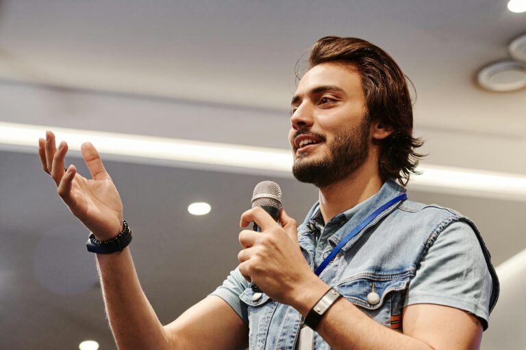 man in blue denim vest holding microphone