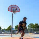 man dribbling a basketball between the legs