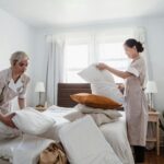 housekeepers changing bedding in hotel room