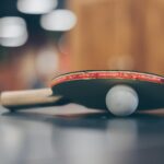 selective focus photo of table tennis ball and ping pong racket