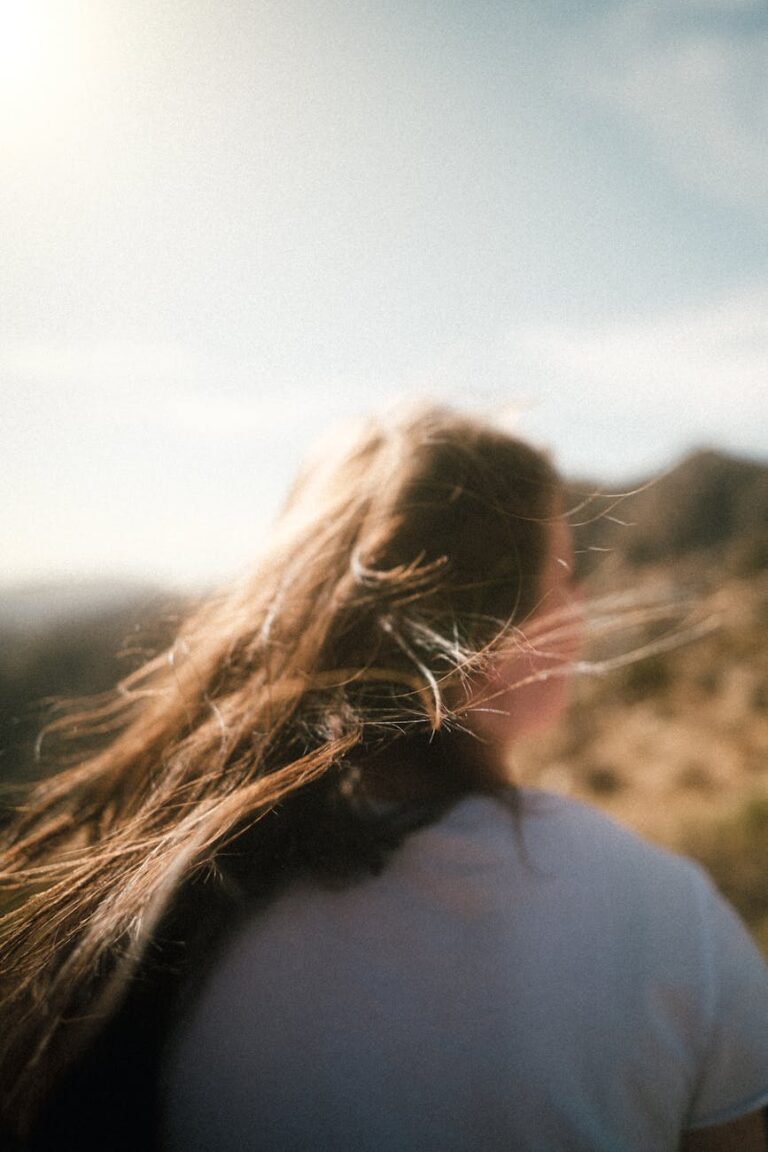 woman in white shirt standing on brown grass field