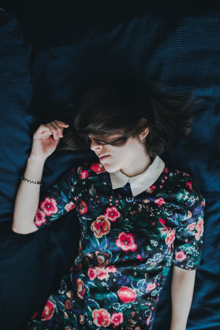peaceful young woman in floral dress resting indoors